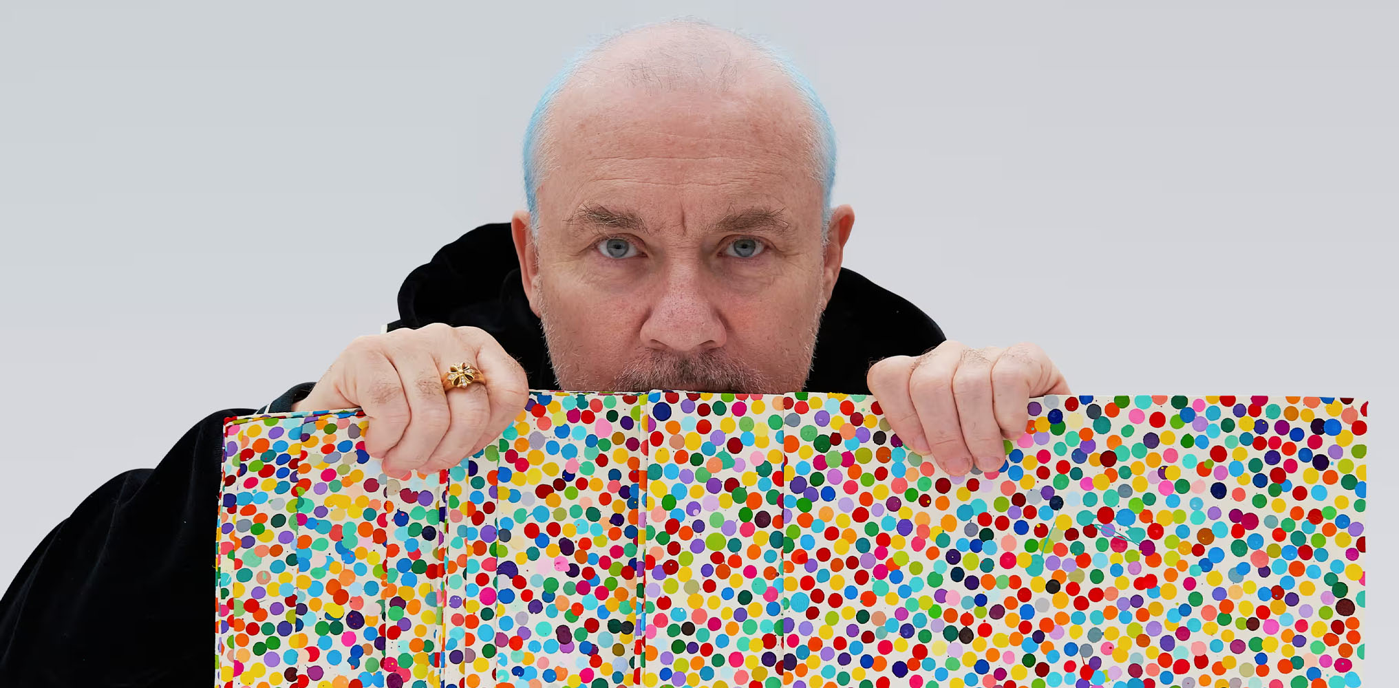 Artist Damien Hirst with paintings from The Currency, one of his more controversial projects.